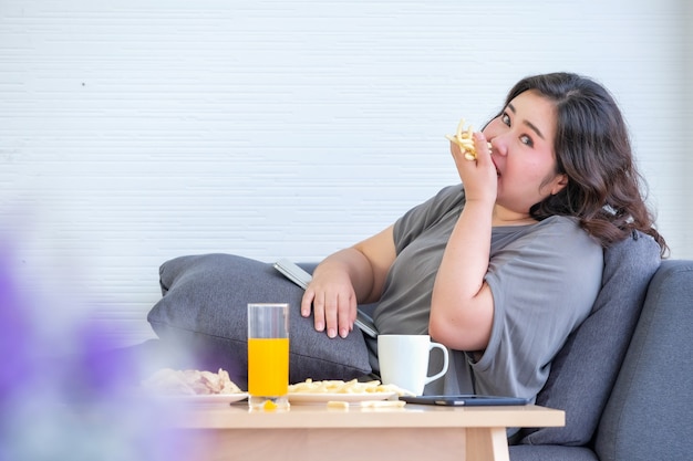 Dikke Aziatische vrouw geniet van het eten van frietjes