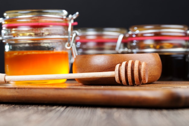 Dikke en zoete honing van verschillende variëteiten en smaken, natuurlijke bijenhoning verpakt in glazen containers, natuurlijke honing zonder suiker en alleen verzameld door bijen