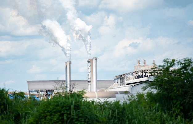 Dikke en zware rook komt uit een enorme, witte rook komt uit schoorstenen of uitlaatpijpen in de fabrieksschoorstenen stoten waterdamp uit die condenseert tot een witachtige wolk voordat deze verdampt.