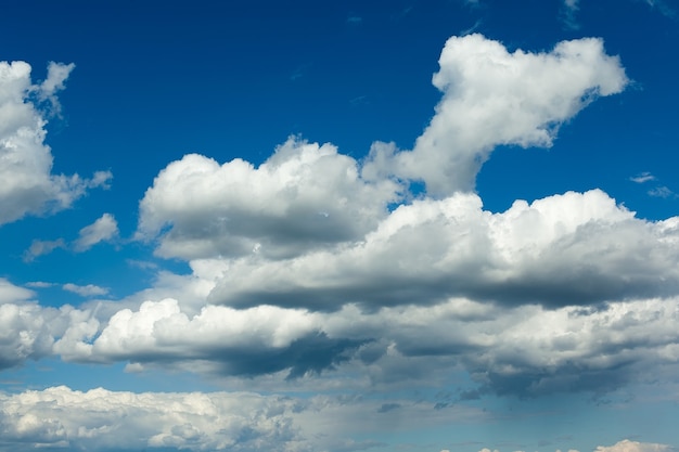 Dikke witte wolken vormen zich in een diepblauwe lucht.