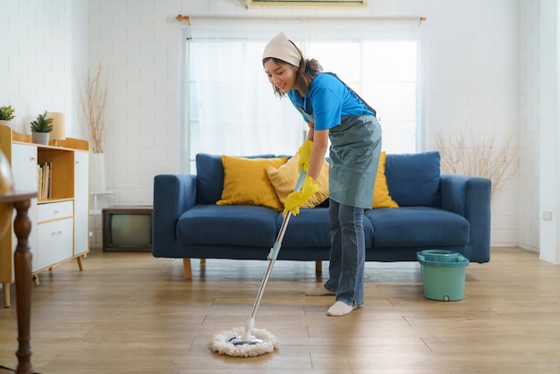 Diligent Asian housewife meticulously mops the living room