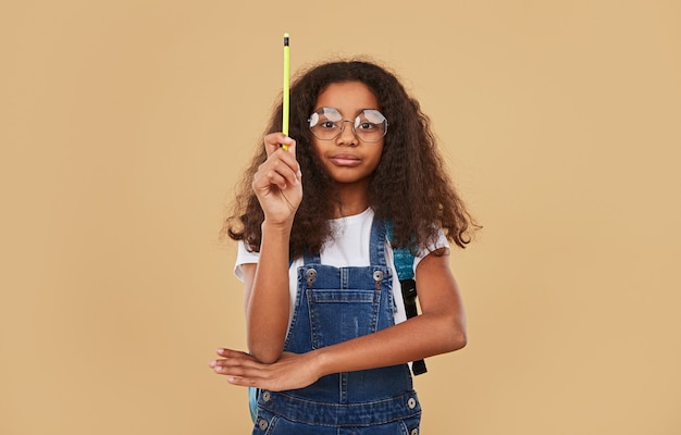 Diligent black schoolgirl raising hand