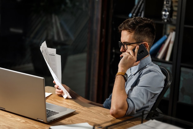 Diligent worker with papers speaking on phone