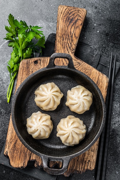 Dim sum gevulde vleesbollen in een pan met kruiden. zwarte achtergrond. bovenaanzicht.