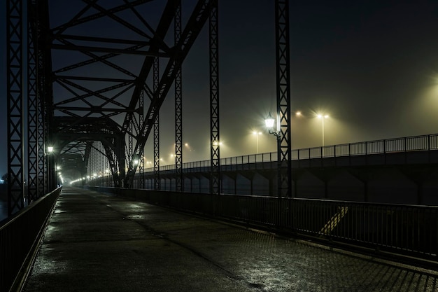 diminishing perspective of bridge against sky at night