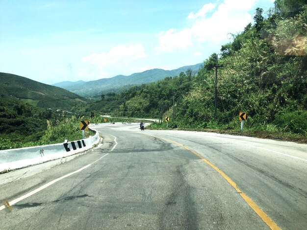 Photo diminishing perspective of road amidst trees against sky