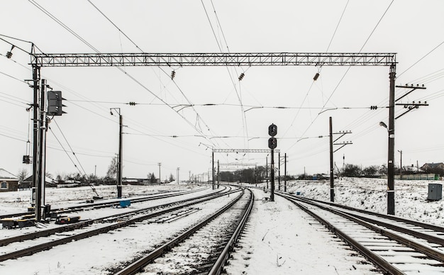 Foto perspettiva in diminuzione dei binari ferroviari coperti di neve contro il cielo