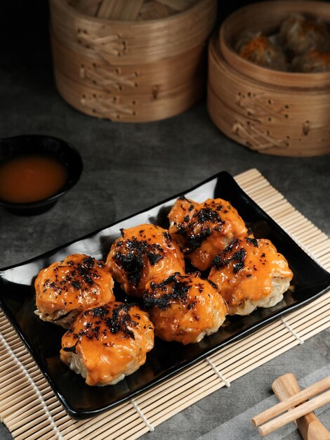 Димсам с японским соусом ментай Подается на тарелке и палочками для еды Выбранный фокус