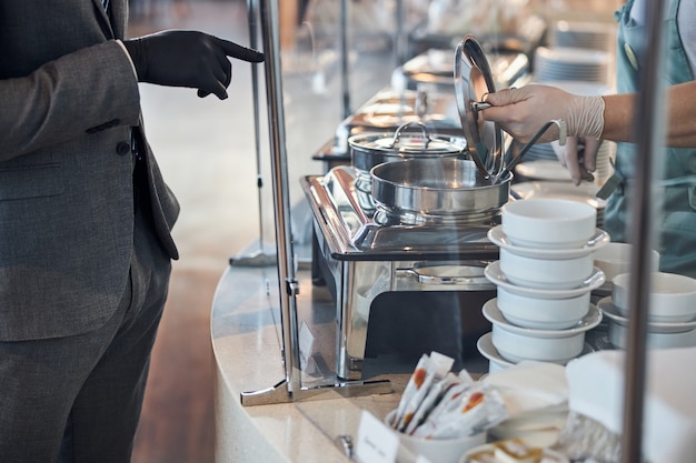 Diner cashier opening a soup pot for a customer