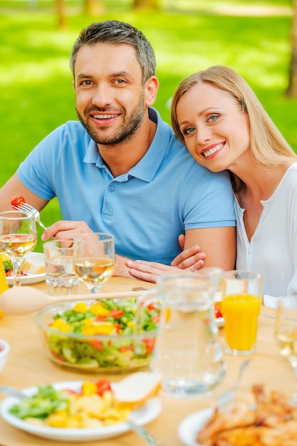 Diner in de frisse lucht. bovenaanzicht van een gelukkig jong liefdevol paar dat samen van een maaltijd geniet terwijl ze buiten aan de eettafel zitten