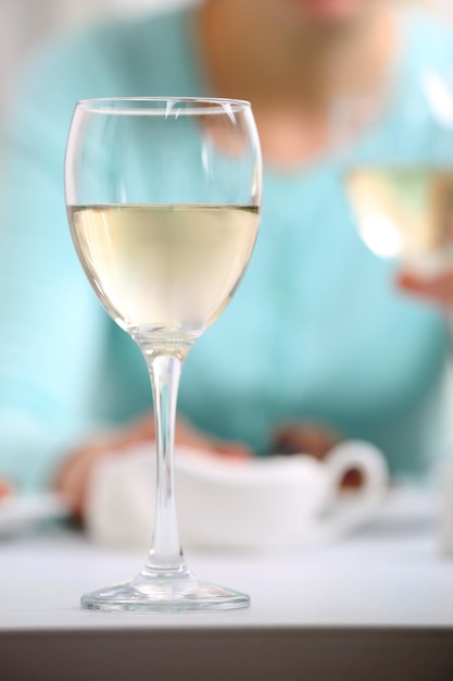Diner met glazen wijn op lichte onscherpe achtergrond