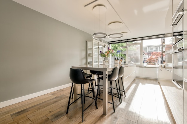 A dining room with a table and chairs in front