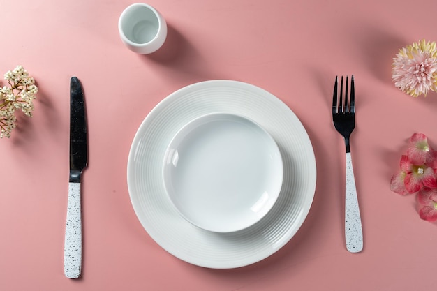 Dining set up with empty plate set placed with a knife and fork ready for food menu