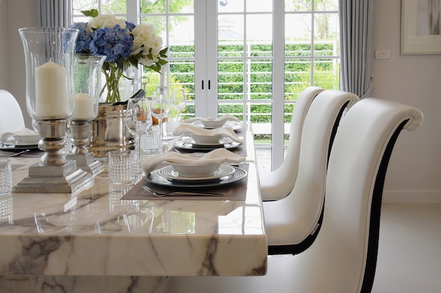 Photo dining table and comfortable chairs in vintage style with elegant table setting