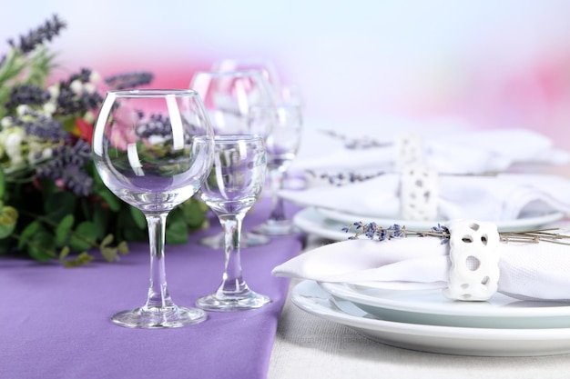 Dining table setting with lavender flowers on table on bright background Lavender wedding concept