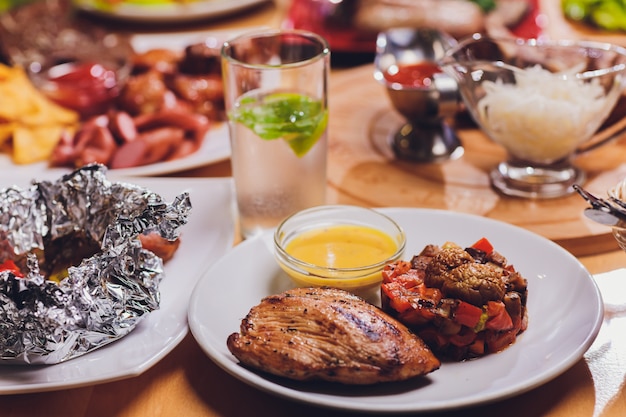 Dining table with a variety of snacks and salads. Salmon, olives, wine, vegetables, grilled fish toast. The concept of a family celebratory dinner.