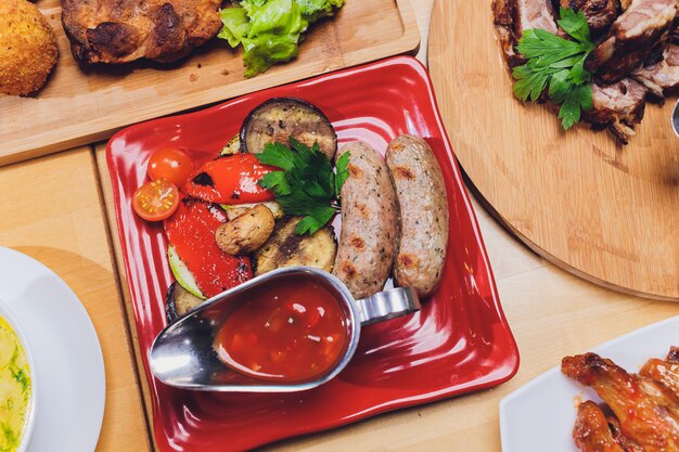 Dining table with a variety of snacks and salads. Salmon, olives, wine, vegetables, grilled fish toast. The concept of a family celebratory dinner.