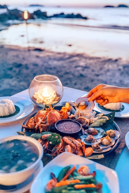 夕暮れのビーチで夕食を食べる