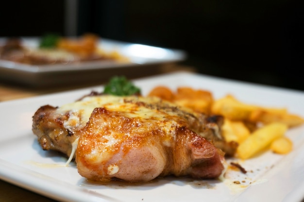 Cena, bistecca di pollo, patatine fritte e salsa.