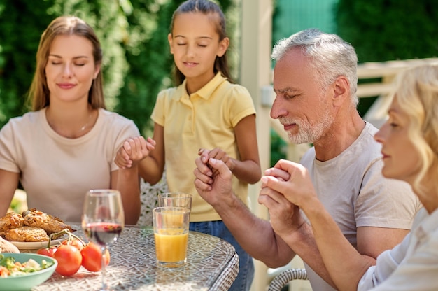 Dinner prayers. A family holding hands and praying before dinner