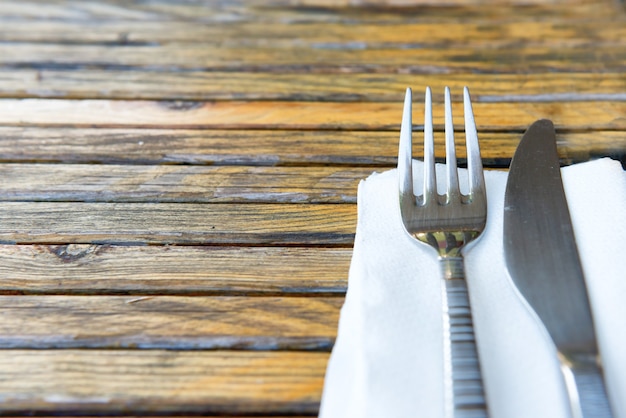 Dinner set- fork and knife on empty wooden table