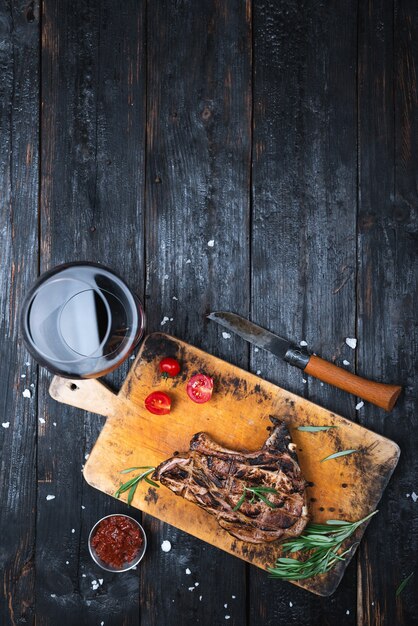 Dinner on the table, juicy grilled steak, a glass of red dry wine, place for text