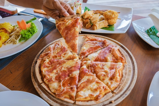 dinner table with pizza and thai food on the beach in Thailand