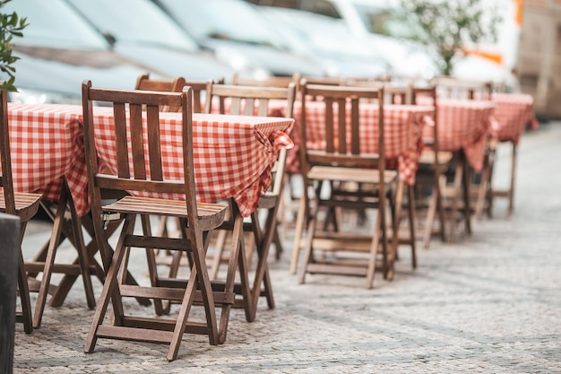 Dinner tables with chairs at summer empty open air cafe\
outdoors