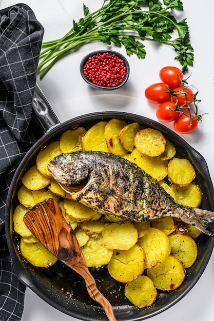 Dinner with grilled sea bream fish, arugula salad with tomatoes, baked potatoes