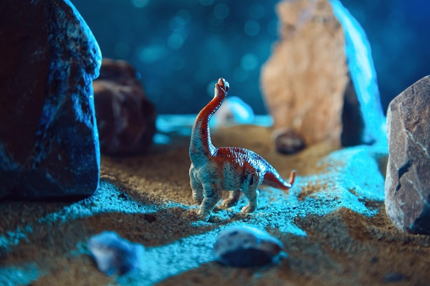 Dinosaur in a rocky gorge at night Creative scenery with a small miniature