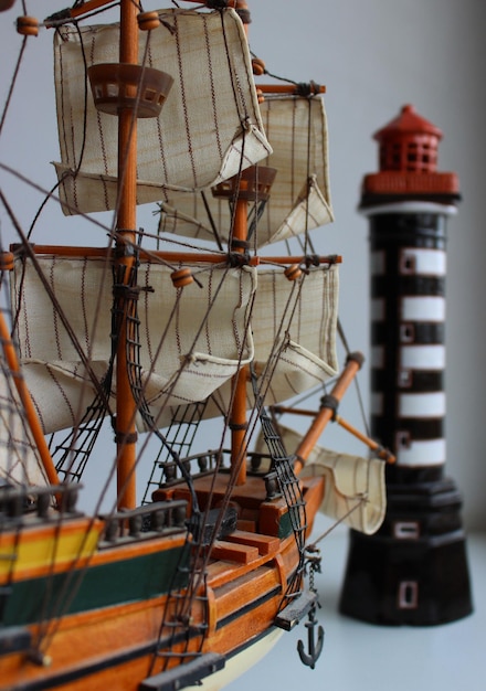 Foto diorama di nave a vela con albero modello in legno e modello di faro isolato su sfondo bianco