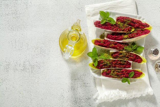 Dip of boiled beets and pistachios in leaves of Belgian Endive with mint. healthy summer snack