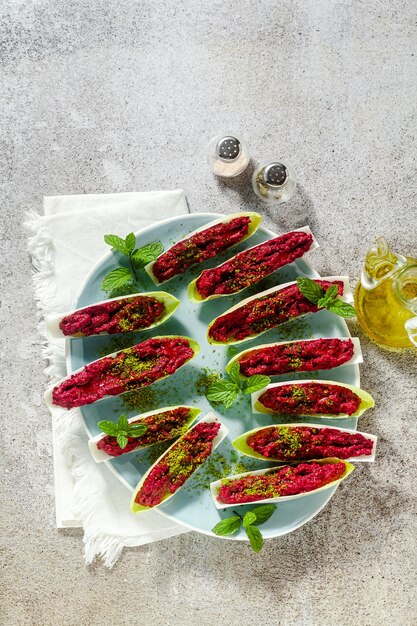 Dip of boiled beets and pistachios in leaves of Belgian Endive with mint. healthy summer snack