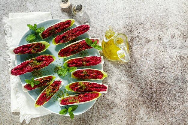 Dip of boiled beets and pistachios in leaves of Belgian Endive with mint. healthy summer snack