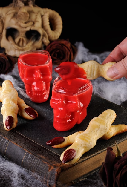 Dip crispy shortbread cookies in the form of witch fingers in hot chocolate "Red Velvet".