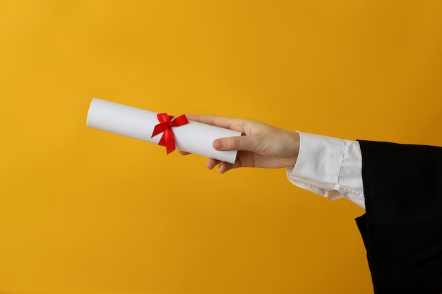 Photo diploma of a university graduate on a yellow background