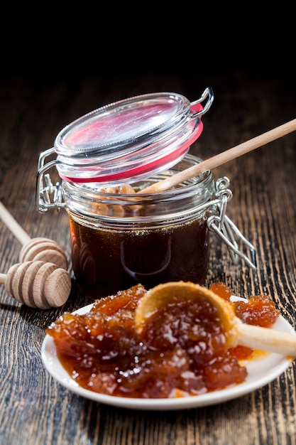 Photo dipped in honey specially made from wood homemade coarse spoon, sweet bee honey and wooden spoon that allows you to transfer and pour honey without dripping and spreading