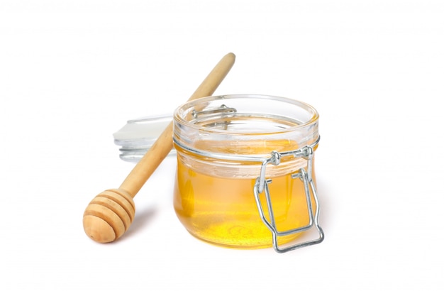 Dipper and glass jar with honey isolated on white