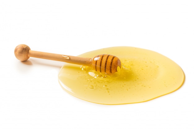 Dipper with honey on a white background