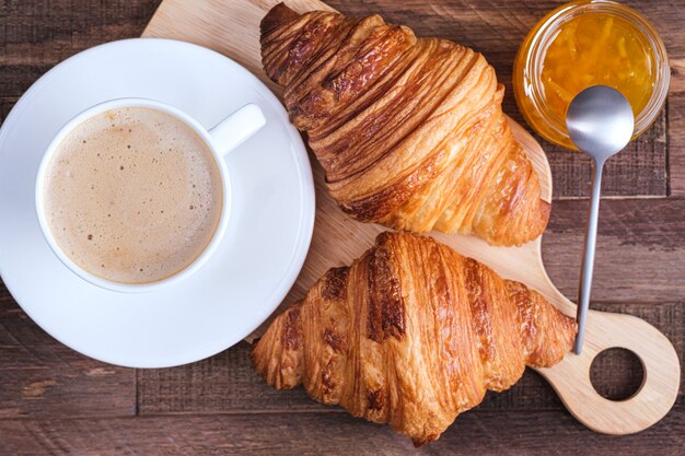 Direct boven cap cappuccino en croissant en jam