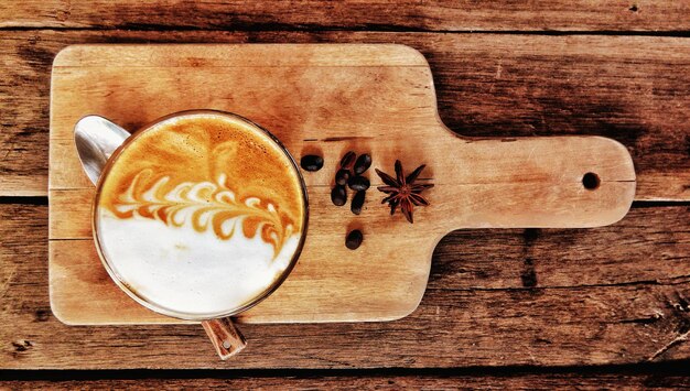 Foto direct boven cappuccino op de snijplank boven de tafel.