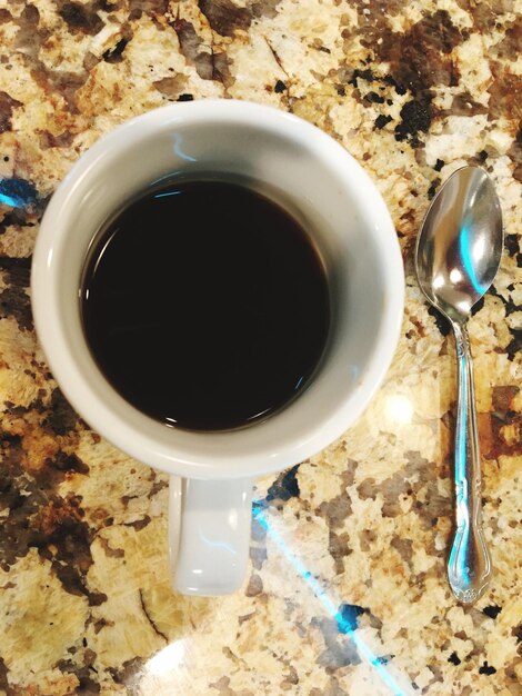 Direct boven de koffie op de tafel.