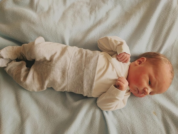 Direct boven de opname van de baby die op het bed ligt.