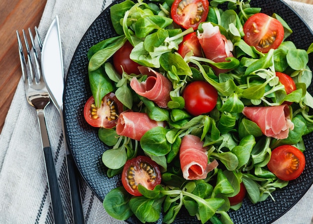 Direct boven de salade op het bord.