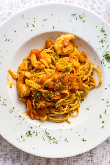 Direct boven een shot pasta met garnalen geserveerd op tafel