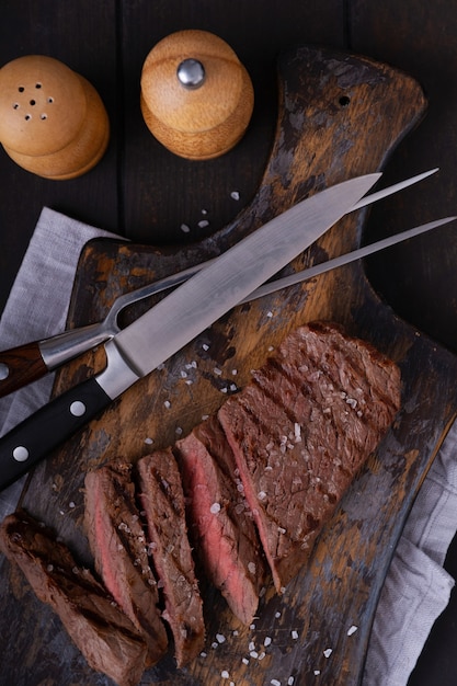 Foto direct boven gesneden biefstuk met kruiden. gekookt voedsel op een snijplank