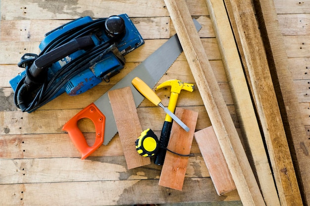 Direct boven het schot van de hamer met handzaag en meetband op een houten plank