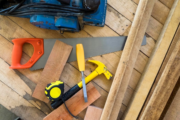 Direct boven het schot van de hamer met handzaag en meetband op een houten plank