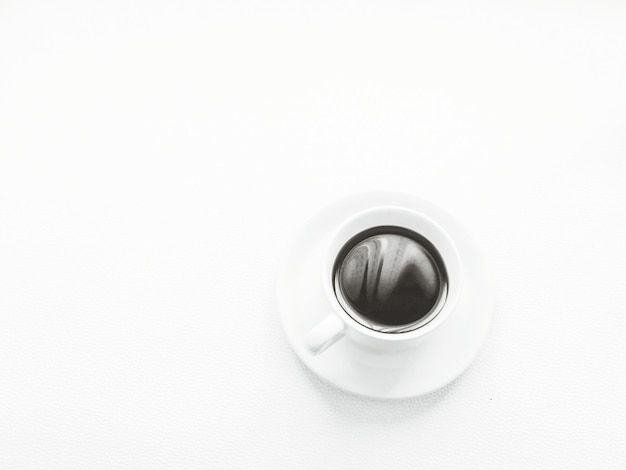 Direct boven opname van een koffiekop op een witte achtergrond