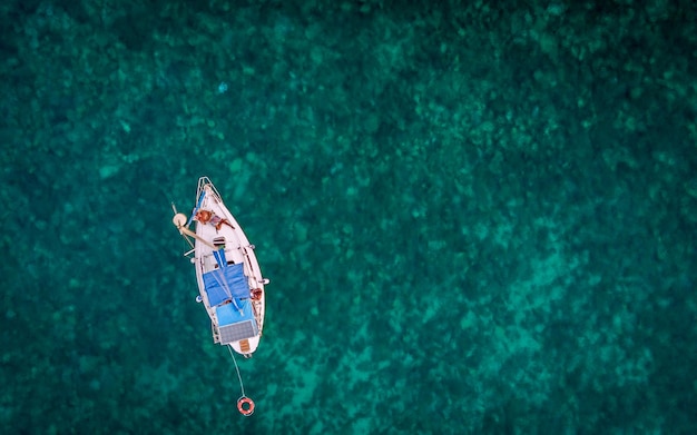 Direct boven opname van een man in een boot op zee